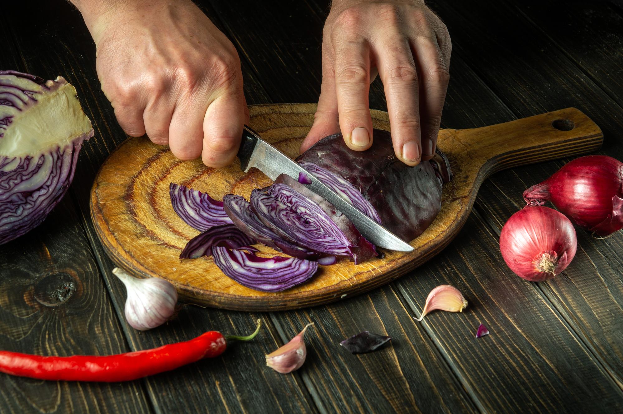 Dettaglio sul taglio delle verdure su tagliere in legno