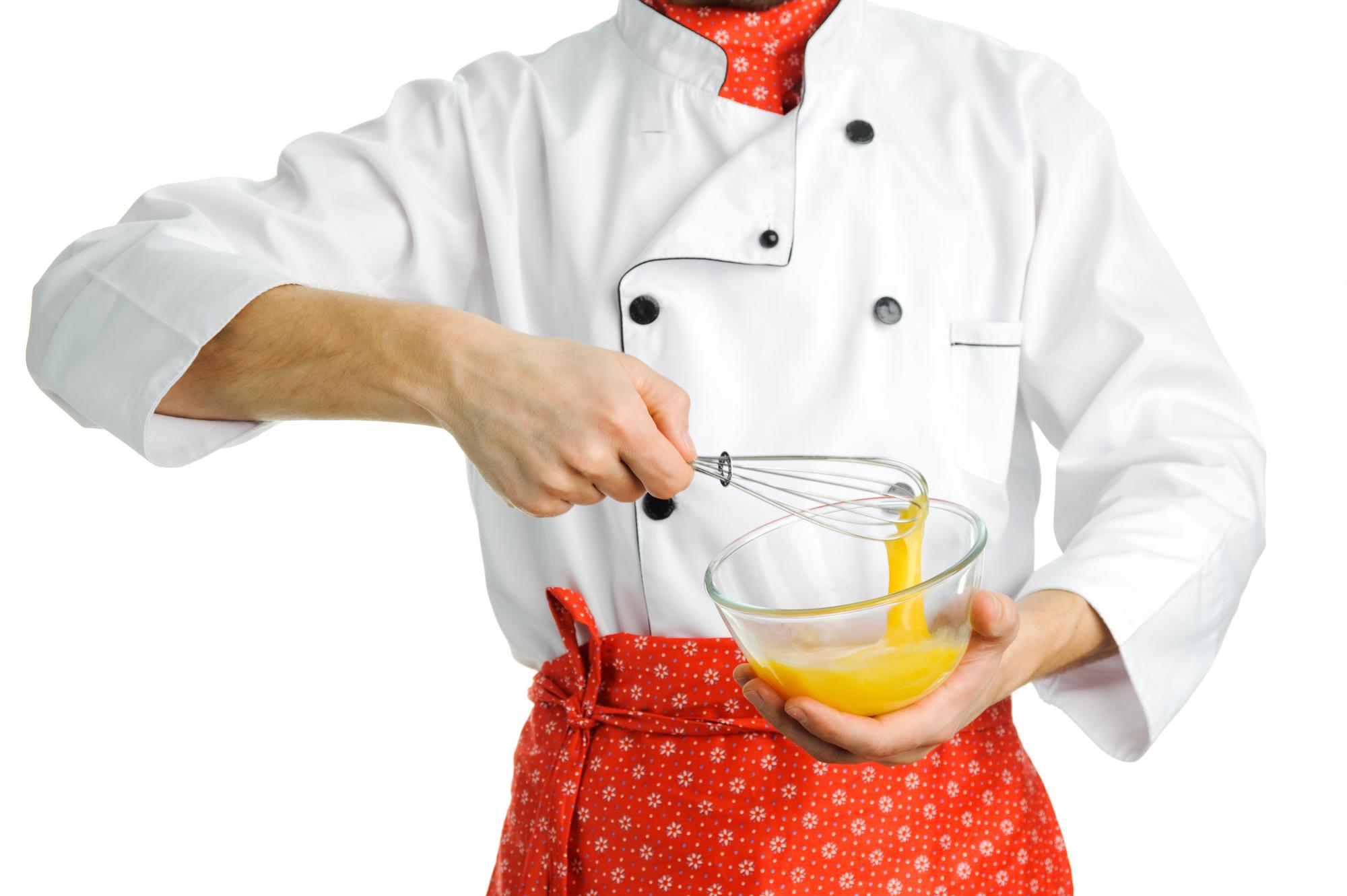 Chef al banco che affetta ingredienti con luce calda